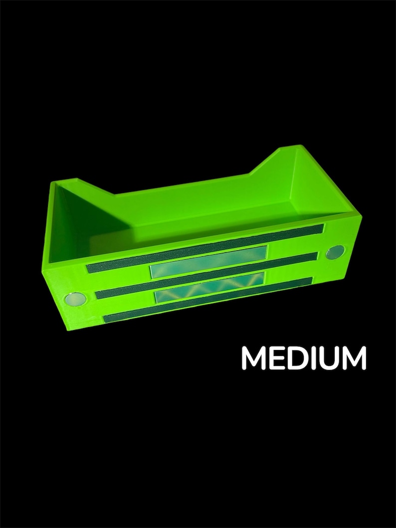 May include: Bright green rectangular storage container with a geometric design on the front. The word "MEDIUM" is printed in white on the bottom of the image. The container has a unique shape with raised sides.