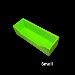 May include: A small, rectangular, neon green container with textured sides and a smooth interior. The word "Small" is printed in white at the bottom of the image against a black background.