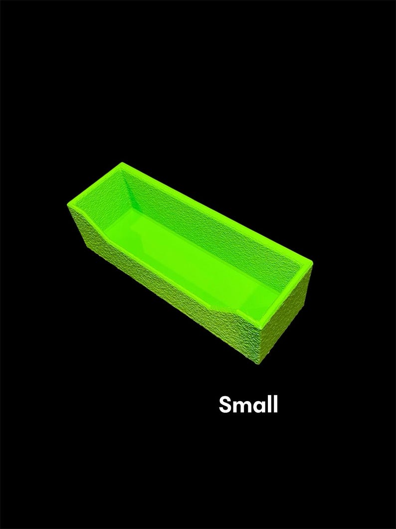 May include: A small, rectangular, neon green container with textured sides and a smooth interior. The word "Small" is printed in white at the bottom of the image against a black background.