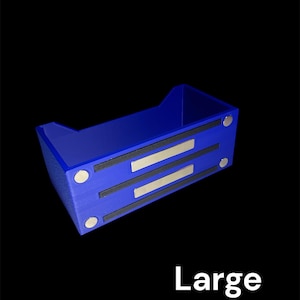 May include: A blue rectangular storage container with a textured surface. The container has two black strips with silver accents and four silver circular magnets. The word "Large" is printed in white.