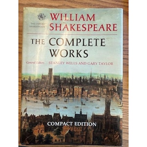 May include: A compact edition of "The Complete Works" by William Shakespeare. The book cover features a detailed illustration of a cityscape with a river, boats, and buildings. The title and author's name are in a serif font.