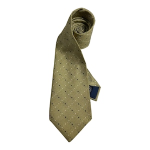 May include: An olive green necktie featuring a subtle textured weave and a repeating pattern of small, alternating black and white dots arranged in a diagonal grid. The tie is partially coiled at the top and includes a dark blue label on the back.