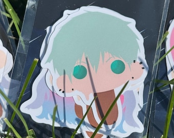 May include: A die-cut sticker featuring a stylized anime-inspired character with mint green hair and iridescent green eyes. The character has a brown outfit and is displayed on a black backing card with the white text BLKSRROW at the top.
