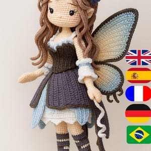 Puede incluir: Muñeca de hada de ganchillo hecha a mano con cabello castaño, una diadema floral y alas azules y marrones. La muñeca viste un vestido azul y marrón con detalles blancos y calcetines a rayas. Un artículo artesanal caprichoso.