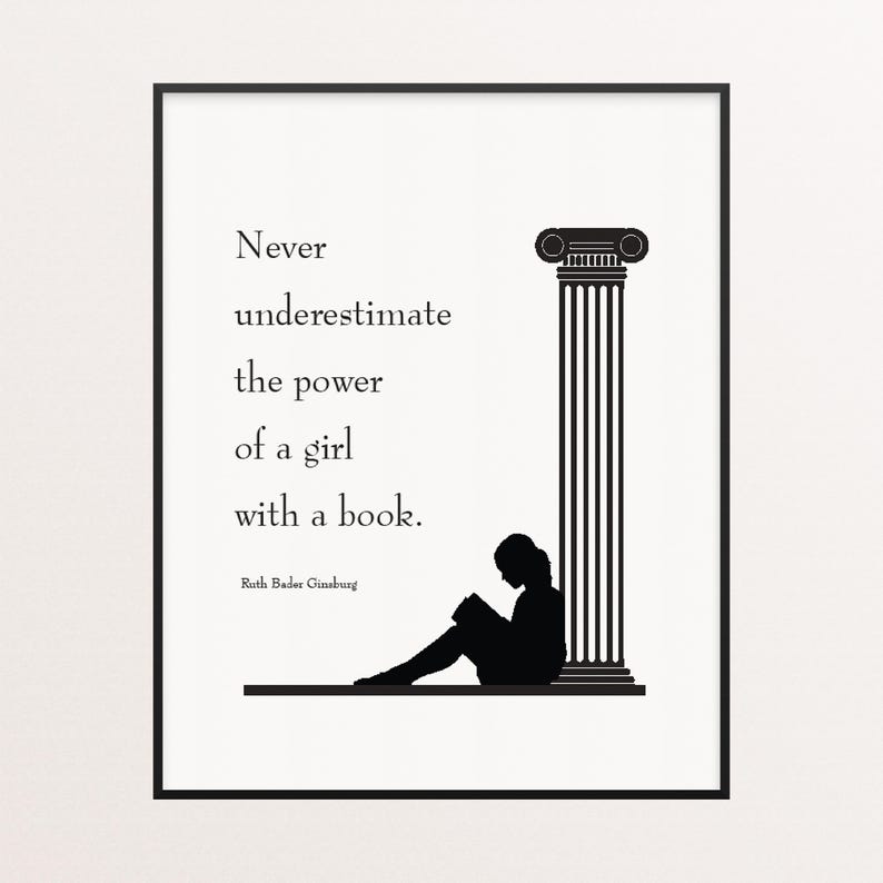 May include: Black and white framed print featuring a silhouette of a person reading a book next to a classical column. The text reads: "Never underestimate the power of a girl with a book." Quote by Ruth Bader Ginsburg.
