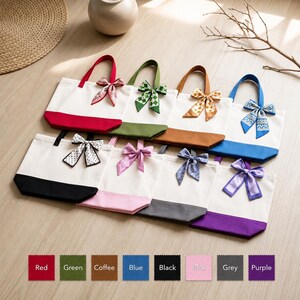 A collection of colorful tote bags with bows, arranged on a wooden surface.
