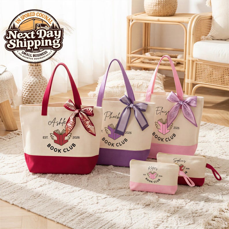 Three tote bags with personalized text and bows, along with two small bags, are displayed on a rug in a room with a woven chair and a basket.