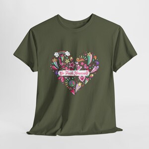 以下が含まれることがあります： オリーブグリーンのTシャツ。中央には星、虹、ハート、ピースマークなどのカラフルな落書きで構成された大きなハート型のグラフィックが描かれています。ハートの中央には「Go Fuck Yourself」というテキストがプリントされています。