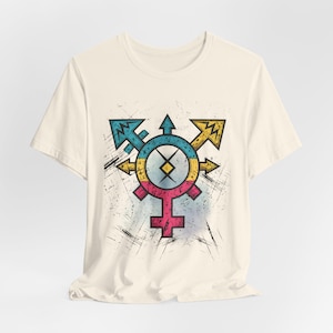 May include: A cream-colored short-sleeve t-shirt featuring a central graphic design. The print displays a complex symbol combining arrows and circular elements in shades of blue, yellow, and pink, with a distressed, scratched texture effect.