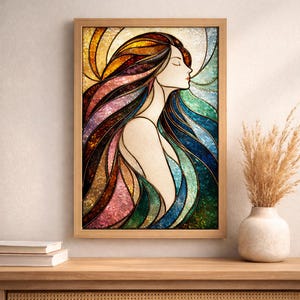 Puede incluir: Una obra de arte en vitral enmarcada que representa a una mujer con cabello largo y ondeante. La obra utiliza una paleta de colores cálidos y fríos, incluyendo naranja, amarillo, rosa, azul y verde. El marco es de madera clara.