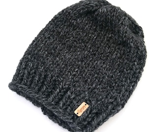 May include: A dark gray knitted beanie with a small brown leather tag that says "Canopy" on it.