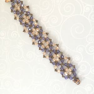 Könnte beinhalten: Ein zartes Armband aus kleinen lila und klaren Glasperlen, die zu einem geometrischen Muster gewebt sind. Das Armband hat einen kupfernen Verschluss.