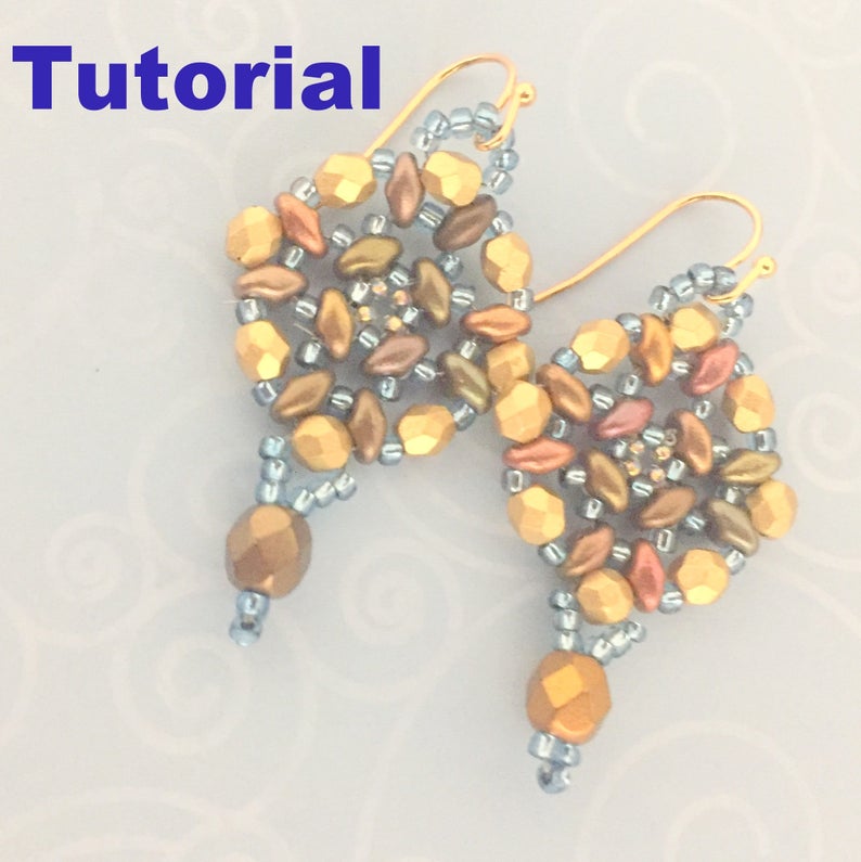 Peut inclure: Une paire de boucles d'oreilles dor&eacute;es en perles avec un motif circulaire pr&eacute;sentant une vari&eacute;t&eacute; de couleurs, notamment l'or, le brun et le bleu.