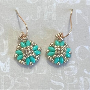 May include: A pair of dangle earrings with a gold wire and a turquoise and silver bead cluster.