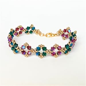 May include: A gold beaded bracelet with alternating green and pink crystal beads in a diamond pattern.