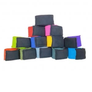 Puede incluir: Una colección de pequeñas bolsas rectangulares en varios colores, incluyendo rojo, rosa, amarillo, azul, verde y morado. Cada bolsa tiene un exterior negro y un interior de color contrastante. Las bolsas están apiladas en forma de pirámide sobre un fondo blanco.