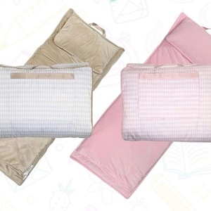 May include: Two sleeping mats with attached pillows and blankets. One set is tan, the other is pink. The blankets have a gingham pattern. Each blanket has a handle for easy carrying. The pillows are rectangular.