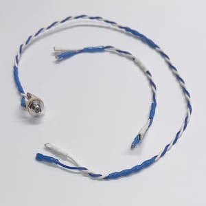 May include: Close-up of electrical wiring with blue and white twisted wires. The wires have blue heat shrink tubing and a metal connector. The wires are on a white background.