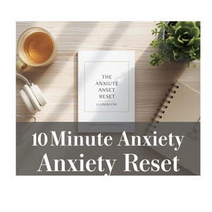 May include: A white book titled "The Anxiety Reset" with gold lettering, next to a cup of tea, headphones, a succulent plant, and a notebook. The text "10 Minute Anxiety Reset" is displayed below the book.