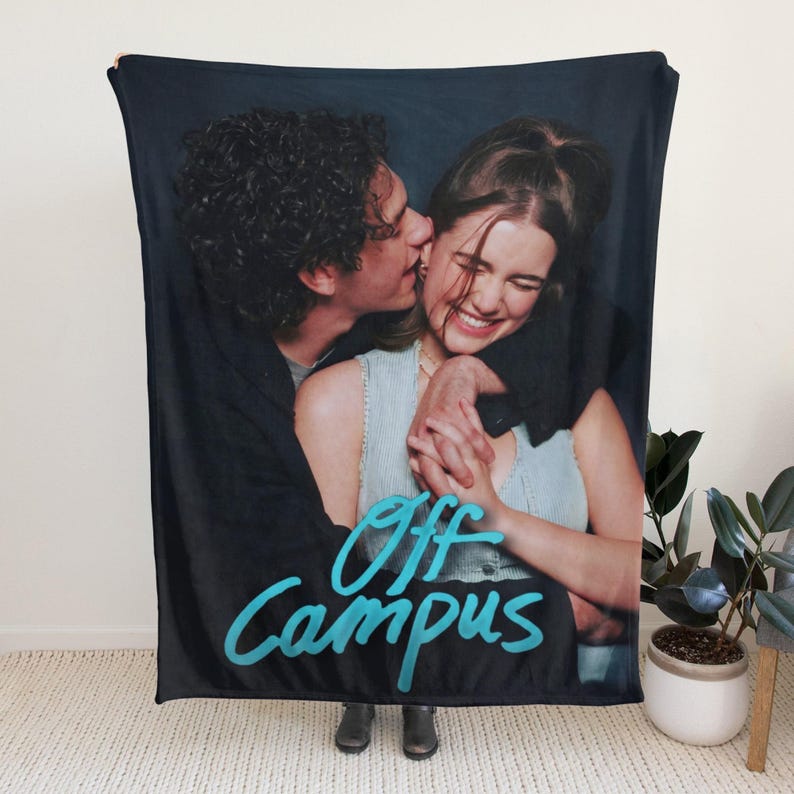 Pu&ograve; includere: Una coperta rettangolare con una stampa fotografica di due persone che si abbracciano. La persona a sinistra indossa una giacca nera, mentre quella a destra indossa un top azzurro. Il testo Off Campus &egrave; stampato in un colore blu brillante.