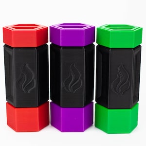 May include: Three hexagonal black containers with a flame design, each topped with a different colored lid: red, purple, and green. The containers are stacked, with the lids and bases in matching colors.