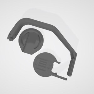 May include: A collection of gray 3D-printed parts, including a curved handle, a circular base with a raised center, and a second circular piece with a rectangular design. The parts are arranged against a white background.