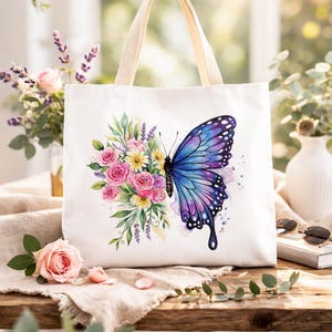 May include: White tote bag featuring a watercolor design of a butterfly and flowers. The butterfly has blue and purple wings. Pink roses, yellow daisies, and green leaves are also depicted. The bag has beige handles.