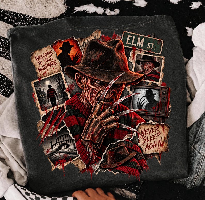 May include: A charcoal gray t-shirt featuring a graphic print of Freddy Krueger with a clawed glove, wearing a fedora and red and black striped sweater. The design includes text reading Welcome to your nightmare, Elm St., and Never sleep again.
