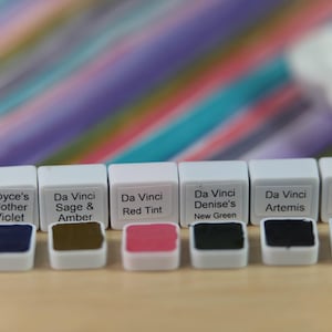 I handpicked these colors for their AMAZING performance!!! The Da Vinci Tropical Palette includes 6 half pans of the following colors: Sage & Amber, Joyce's Mother Violet, Denise's New Green, Artemis, Seaglass, Da Vinci Red Tint. Each is a professional-grade fine arts watercolor paint. I have these in stock, ready to ship in Half Pans, Quarter Pans, or dot cards.