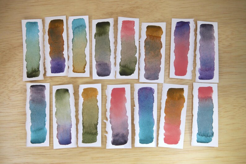 Swatches of the Da Vinci Tropical Palette which includes 6 half pans of the following colors: Sage & Amber, Joyce's Mother Violet, Denise's New Green, Artemis, Seaglass, Da Vinci Red Tint