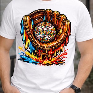 May include: White t-shirt featuring a colorful graphic of a baseball glove holding a baseball. The baseball and glove are brown with colorful accents, and the design has a dripping paint effect in various colors.