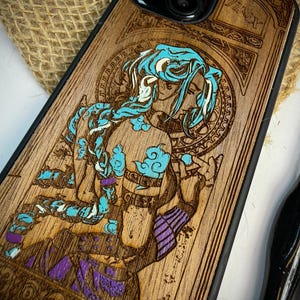 K&ouml;nnte beinhalten: Handy-H&uuml;lle aus Holz mit einem lasergravierten Design eines Charakters mit blauen Haaren und lila Akzenten. Das Wort "Jinx" ist oben sichtbar. Die H&uuml;lle hat einen schwarzen Rand und eine nat&uuml;rliche Holzmaserung.