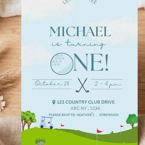 May include: A light blue birthday invitation card featuring a golf theme with a golf ball, clubs, and a green course. The text reads: LET'S PAR-TEE, MICHAEL is turning ONE!, October 28, 2-4 pm, 123 COUNTRY CLUB DRIVE, ABC NY, 1234, RSVP TO HEATHER 0798765432.