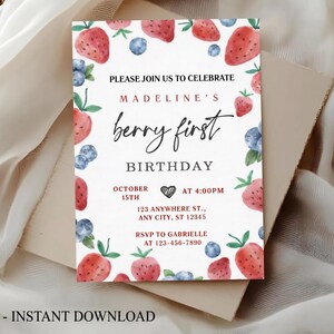 May include: A rectangular birthday invitation card featuring a watercolor border of red strawberries and blue blueberries. The text reads: PLEASE JOIN US TO CELEBRATE MADELINE'S berry first BIRTHDAY OCTOBER 15TH AT 4:00PM 123 ANYWHERE ST., ANY CITY, ST 12345 RSVP TO GABRIELLE AT 123-456-7890.