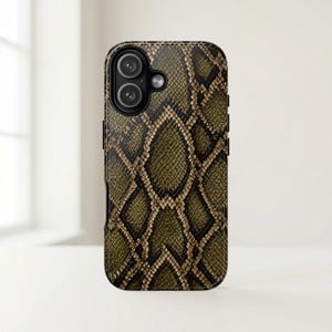 Puede incluir: Funda para smartphone con diseño de piel de serpiente en tonos verde oliva, marrón y negro. La funda tiene un recorte para la cámara y bordes negros. El diseño imita la textura de las escamas de serpiente.