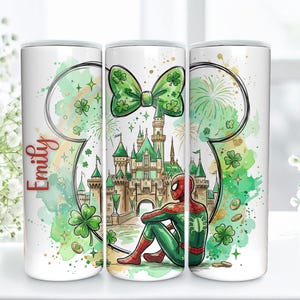 May include: A white tumbler featuring a watercolor design with a green bow, castle, and Spider-Man. The design includes shamrocks, fireworks, and the name "Emily" in red script. The tumbler has a cylindrical shape.