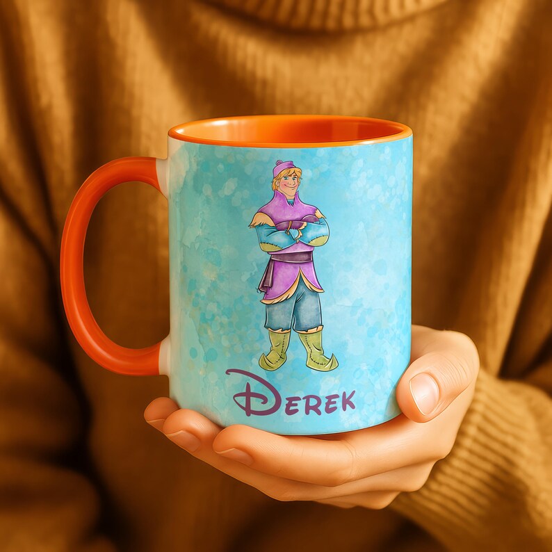 Peut inclure: Une tasse en c&eacute;ramique avec une anse et un int&eacute;rieur orange. L'ext&eacute;rieur pr&eacute;sente un motif de style aquarelle avec un personnage de dessin anim&eacute; en violet, bleu et vert. Le nom "Derek" est imprim&eacute; en police stylis&eacute;e au bas de la tasse.