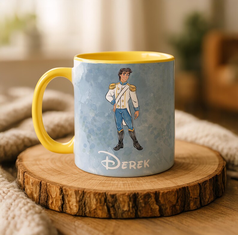 May include: A ceramic mug with a yellow handle and interior. The exterior features a cartoon illustration of a prince in a white and blue uniform against a light blue watercolor background. The name "Derek" is written in white.