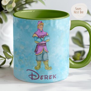 Peut inclure: Mug en c&eacute;ramique avec une anse et un int&eacute;rieur verts. La tasse pr&eacute;sente une illustration &agrave; l'aquarelle d'un personnage de dessin anim&eacute; v&ecirc;tu d'une tenue violette et bleue. Le nom "Derek" est imprim&eacute; en violet.