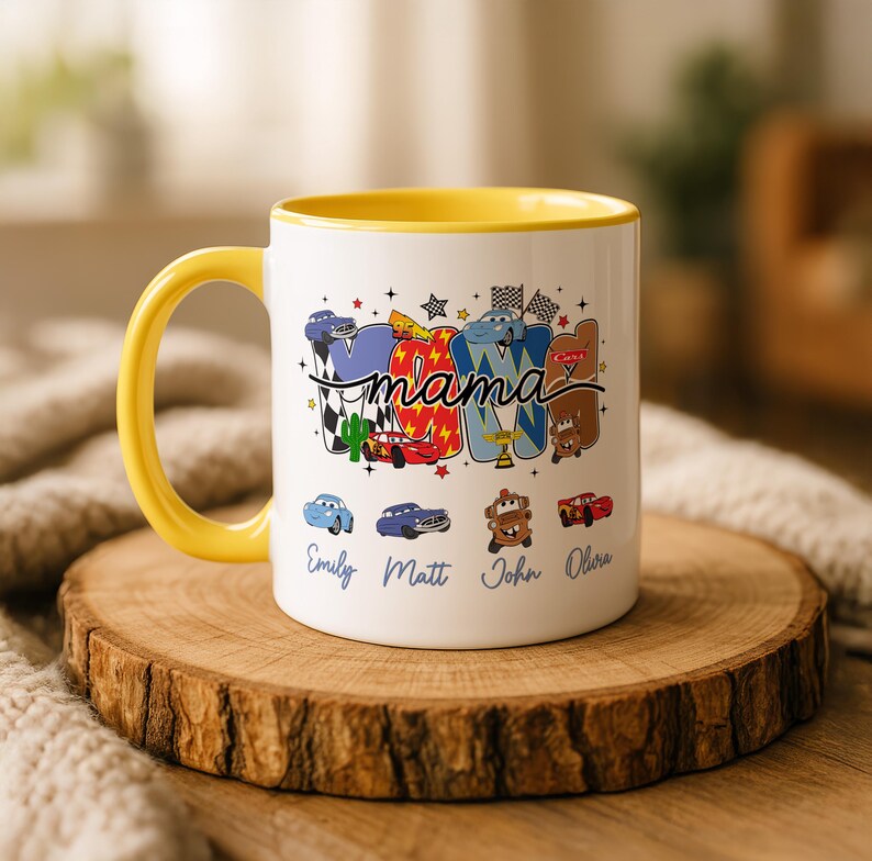 以下が含まれることがあります： 黄色いハンドルと内側を持つ白いセラミック製のマグカップ。漫画のレーシングカーのカラフルなグラフィックと、筆記体で書かれた「mama」という文字が特徴です。グラフィックの下には、Emily、Matt、John、Oliviaという名前が青色で印刷されています。