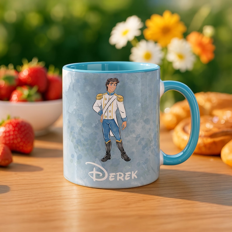 May include: A light blue ceramic mug with a teal handle and interior. The mug features a watercolor design and a cartoon illustration of a prince. The name "Derek" is printed on the front.