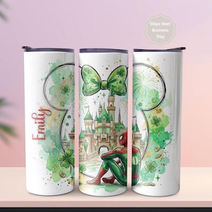 May include: Three white insulated tumblers with black lids. Each tumbler features a different design: a green bow, a castle scene with Spider-Man, and a Mickey Mouse head outline with the name "Emily" in red. The designs include green shamrocks and gold accents.