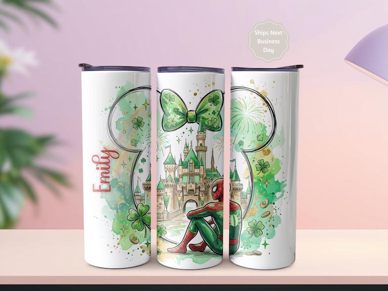 May include: Three white insulated tumblers with black lids. Each tumbler features a different design: a green bow, a castle scene with Spider-Man, and a Mickey Mouse head outline with the name "Emily" in red. The designs include green shamrocks and gold accents.