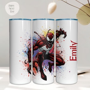 May include: White tumbler with a blue rim featuring a red and black comic book character design. The character is set against a colorful splatter background. The name "Emily" is printed in red on the side.