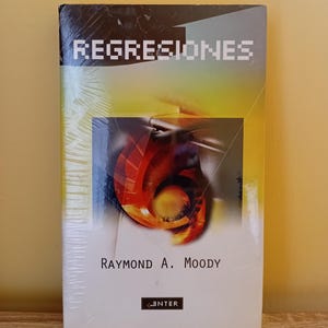 May include: A paperback book titled "REGRESIONES" by Raymond A. Moody. The cover features a vibrant abstract design with red, orange, and yellow hues. The book is wrapped in clear plastic, with the "ENTER" logo at the bottom.