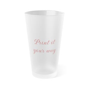 May include: A tall, frosted white glass with a slightly tapered shape. The words "Print it your way" are printed in a delicate, cursive font in a soft pink color on the front of the glass. The glass is empty and stands against a white background.