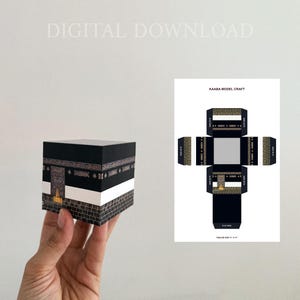 Puede incluir: Un modelo en miniatura de la Kaaba, predominantemente negro con detalles dorados y blancos, sostenido en una mano. El modelo presenta detalles intrincados y está acompañado de una plantilla plana y desplegada. Las palabras "DIGITAL DOWNLOAD" son visibles.