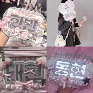 May include: Pink and white decorative accessories, including a fan, a bag, and a hand-held item, all featuring a similar design. The items have a lace trim, bows, and star accents. The text on the items is in a foreign language.