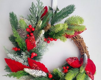 Red and Green Christmas wreath.  Artificial flower Christmas decoration. Xmas door, wall hanging. Foliage and red berries. Velvet leaves
