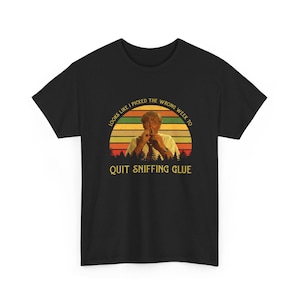 May include: Black t-shirt with a graphic featuring a man with a retro sunset design. The text reads "Looks like I picked the wrong week to quit sniffing glue."